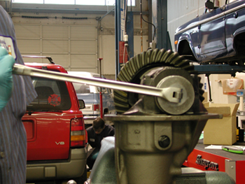 Properly setting preload with side adjusters - There are several types of rear ends that use a threaded side adjuster be it a single adjuster or one on both sides of carrier. The most commonly known rears with this type of carrier adjustment are the Chrysler 7.25-8.25-8.75-9.25, Ford 9”, GM 8.25” IFS, Suzuki Samurai, & Toyota. The GM 9.5” is a little different than most as one side uses shims but the other side is the threaded adjuster.

Randy’s has tools that work with a 1 2” drive ratchet or breaker bar that work much better than beating the heck out of the adjuster with a punch & hammer. These side adjuster tools are priced starting at $29.00.

Most people are reluctant to really crank on these adjusters to preload the carrier bearings. It is perfectly normal to have 150-200 ft lbs of torque on the side adjusters. It is very important to obtain good preload to avoid damage to your differential. At Randy’s, our service shop uses a 1 2” breaker bar, as shown in illustration 1A. The reason we do this is because as you accelerate, the pinion wants to make the ring gear deflect. The more power, the more it will tend deflect. Housings always flex, some more than others, depending on whether it’s stock or an aftermarket nodular. If you put a lot of preload on the carrier bearings it also preloads the housing. Since the housing is already flexed, it is not likely to flex even more causing the ring gear to move away from the pinion resulting in broken teeth.